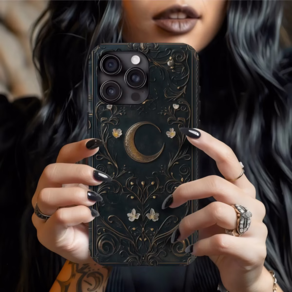 A dark-haired model with gothic rings and black nails holds the Dark Celestial phone case, showcasing the crescent moon design.