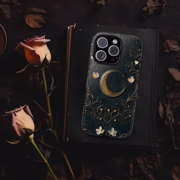 Case shown flat on a black journal surrounded by dried roses, emphasizing its antique spellbook aesthetic.